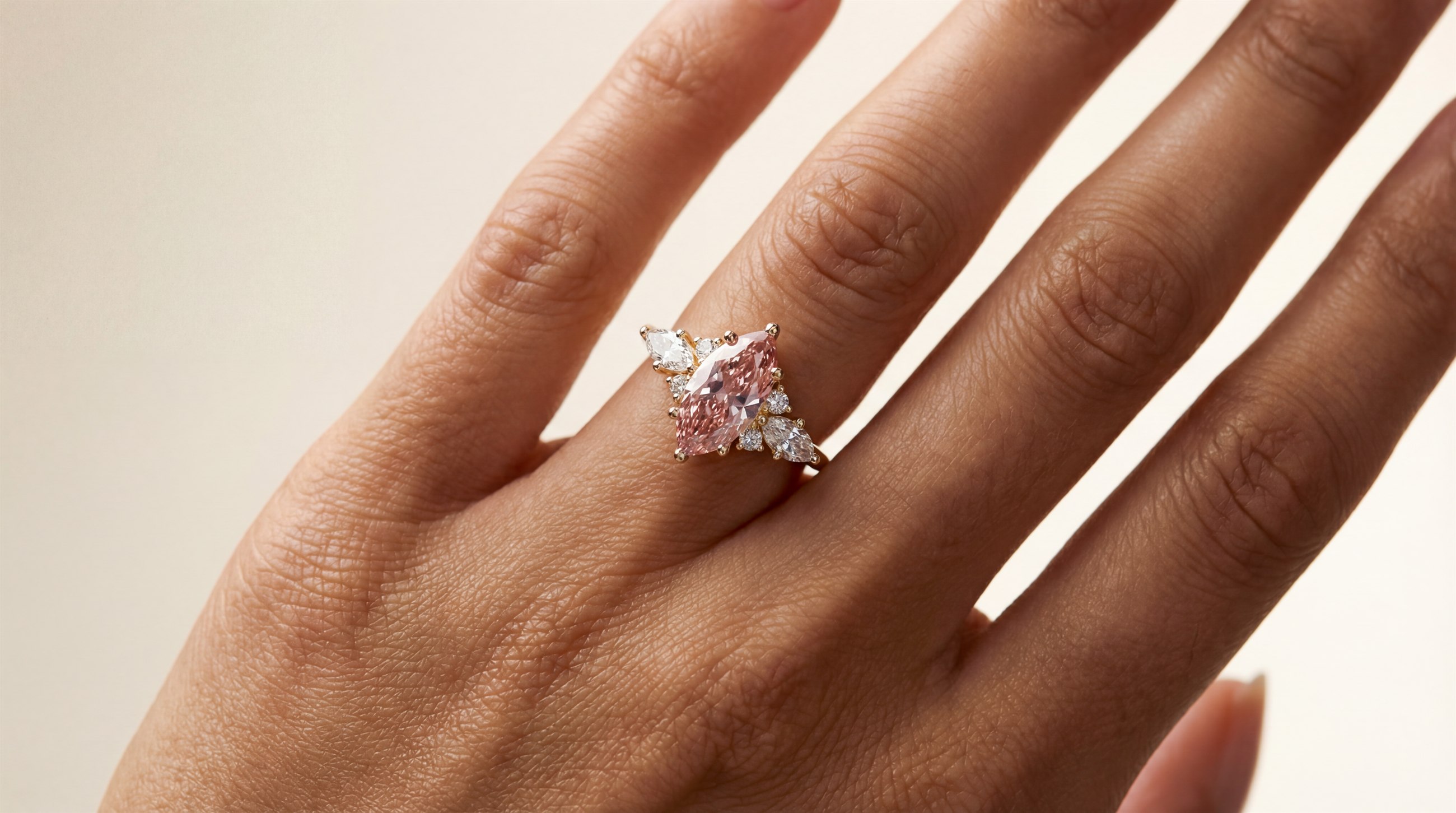 Close-up of a woman wearing a pink diamond engagement ring
