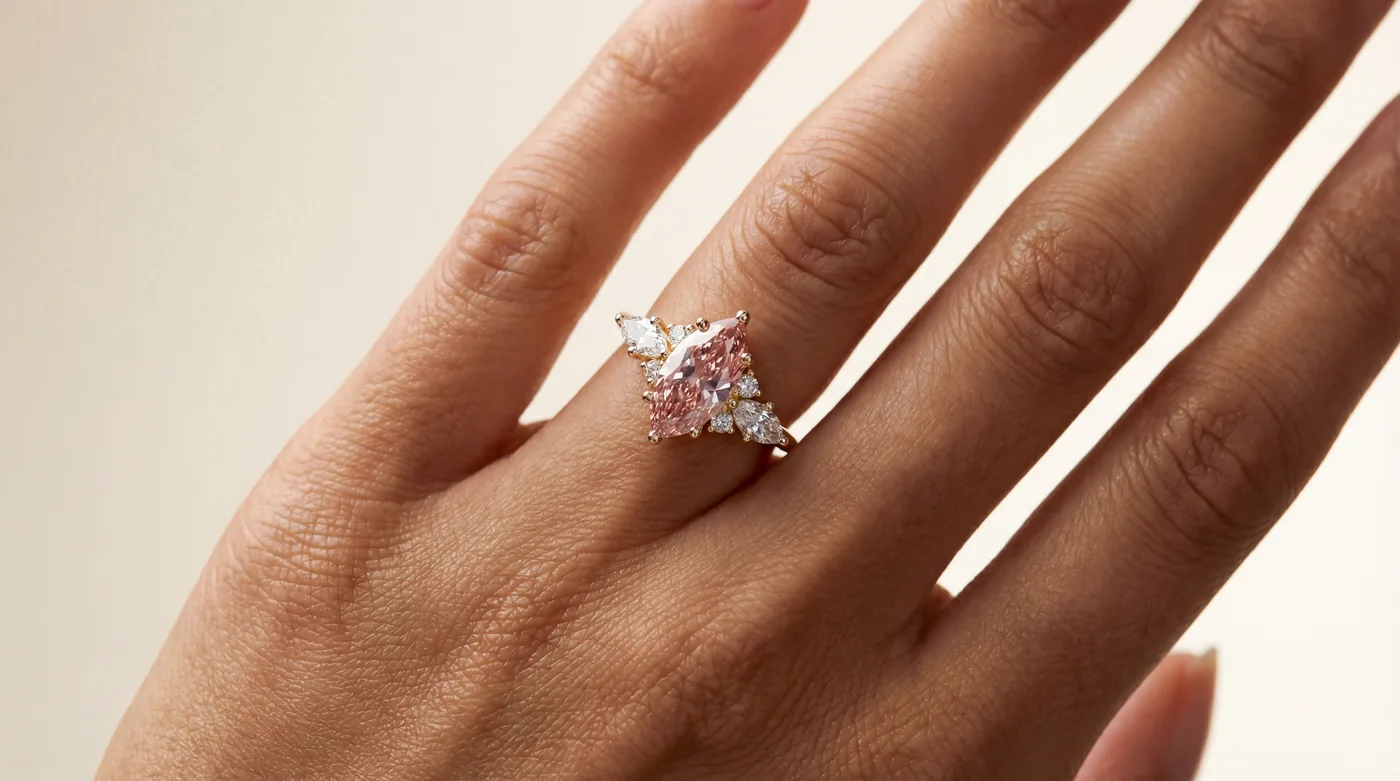 Pink marquise diamond engagement ring with pear and round accent diamonds in yellow gold